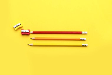 Renk arkaplanındaki sıradan kalemler ve keskinleştiriciler