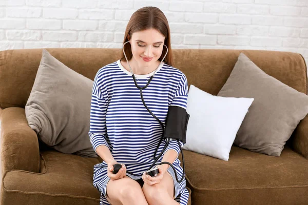 Young Woman Measuring Her Blood Pressure Home — Stock Photo, Image