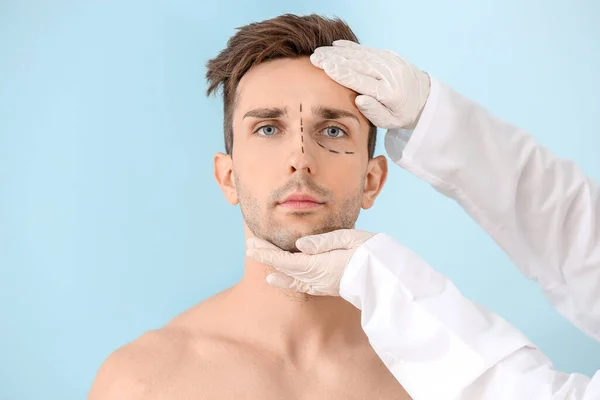 Plastisch Chirurg Aanraken Gezicht Van Jonge Man Kleur Achtergrond — Stockfoto