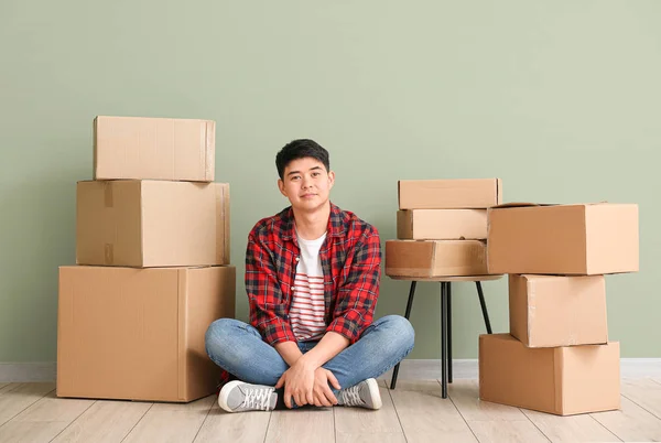 Asian Man Moving Boxes Sitting Color Wall — Stock Photo, Image