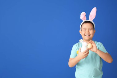 Paskalya yumurtası ve renkli tavşanı olan küçük Asyalı çocuk.