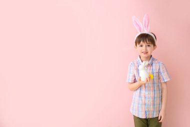 Paskalya yumurtası ve renkli tavşanı olan küçük bir çocuk.