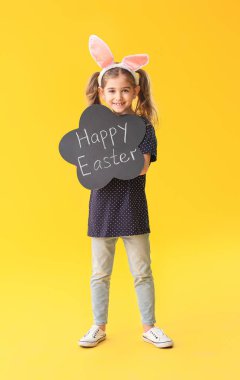 Elinde yazı tahtası olan küçük bir kız. Arka planda Mutlu Paskalyalar.