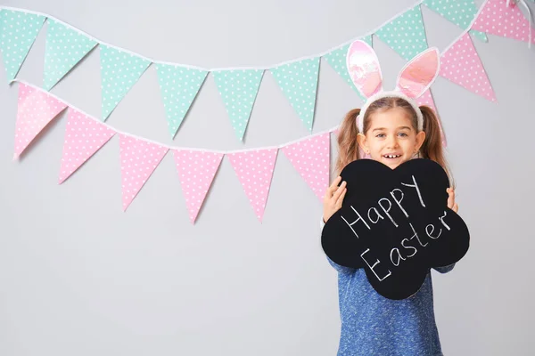 小女孩拿着黑板 上面有灰色背景的文字Happy Easter — 图库照片