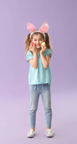 Kleines Mädchen Mit Ostereiern Und Hasenohren Auf Farbigem Hintergrund — Stockfoto