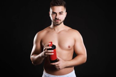 Karanlık arka planda protein sallama ile sportif adam