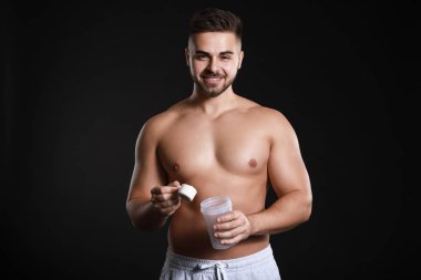 Karanlık arka planda protein ile sportif adam