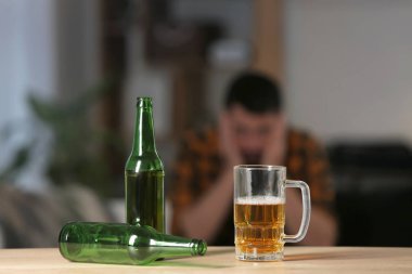 Şişeler ve bir kupa bira masanın üstünde. Alkolizm kavramı