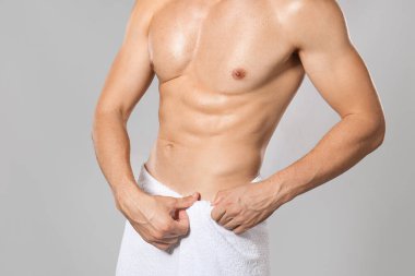 Gri arka plandaki tüy dökümünden sonra yakışıklı genç adam.