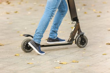 Genç adam açık havada bir tekme scooter sürme