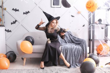 Cadılar Bayramı 'nda evde cadı gibi giyinmiş güzel bir kadın.