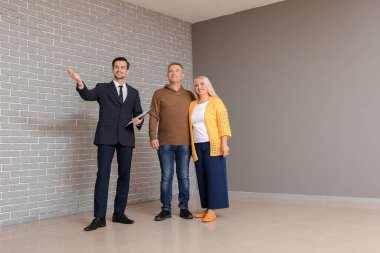 Erkek emlakçı olgun çifte yeni bir ev gösteriyor.