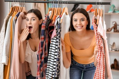 Young women choosing clothes in modern store