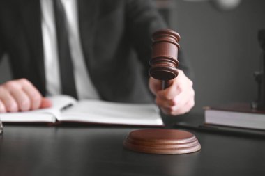 Hakim tokmağı olan erkek avukat iş yerinde oturuyor.