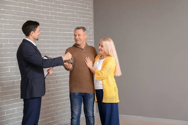 Real Estate Agent Giving Key New House Mature Couple Indoors — Stock Photo, Image