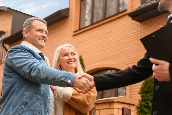 Männlich Immobilienmakler Schüttelt Hände Mit Reifem Paar Der Nähe Haus — Stockfoto