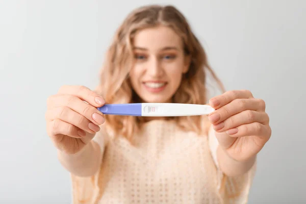 Ευτυχισμένη Νεαρή Γυναίκα Τεστ Εγκυμοσύνης Στο Φως Φόντο — Φωτογραφία Αρχείου