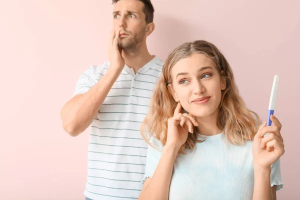 Emotionales Junges Paar Mit Schwangerschaftstest Auf Farbigem Hintergrund — Stockfoto