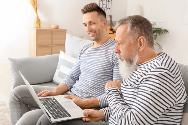 Senior Man Zijn Volwassen Zoon Met Behulp Van Laptop Thuis — Stockfoto
