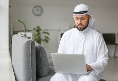 Ofisinde dizüstü bilgisayarlı Arap işadamı