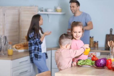 Little children with parents in kitchen