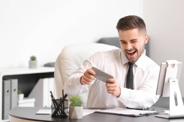 Ofisinde cep telefonu olan mutlu bir işadamı