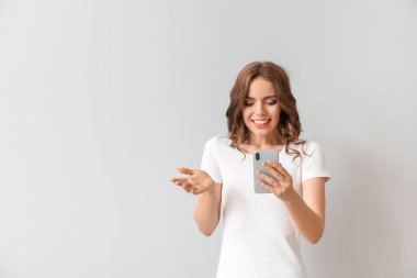 Arka planda cep telefonu olan genç bir kadın.