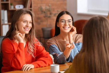 Güzel genç iş kadınları ofiste birlikte çalışıyorlar.