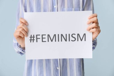 Feminizm ve hashtag kelimelerini içeren kağıt kağıtlar tutan kadın, yakın plan