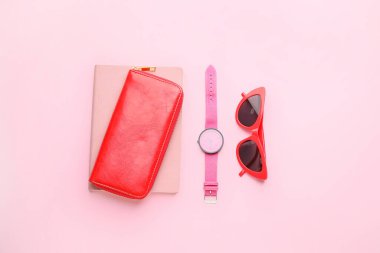 Güneş gözlüklü cüzdan ve renk arkaplan üzerindeki saat