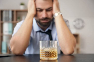 Ofisinde bir bardak viskisi olan sarhoş bir işadamı. Alkolizm kavramı