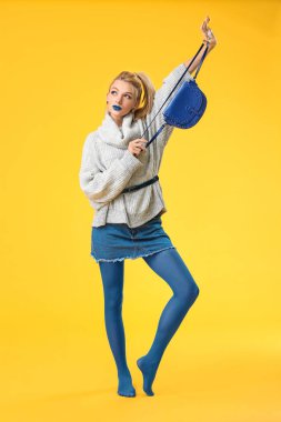 Yaratıcı makyajlı ve arka planda kalın kazaklı genç bir kadın.