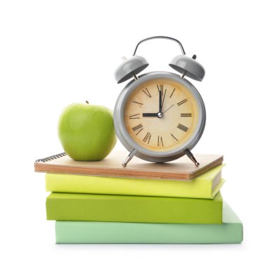Okul kitapları, beyaz arka planda elma ve saat. Çalışma zamanı.