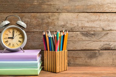 Okul malzemeleri ve saat seti masanın üzerinde. Çalışma zamanı.