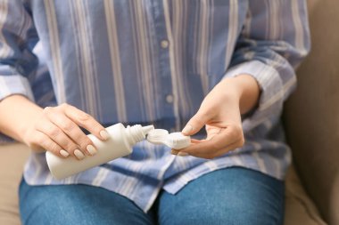 Kadın konteynıra kontak lensli solüsyon dolduruyor, yakın plan.