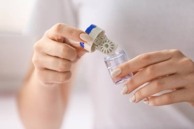 Konteynırı kontak lensli bir kadın tutuyor, yakın plan.