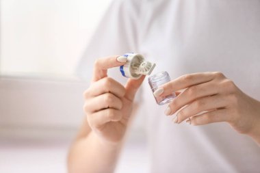 Konteynırı kontak lensli bir kadın tutuyor, yakın plan.