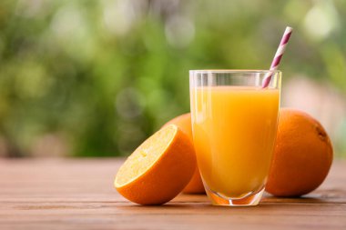 Dışarıdaki masada bir bardak taze portakal suyu ve meyve.