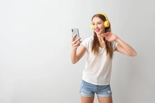 Giovane Donna Con Cellulare Che Ascolta Musica Sfondo Chiaro — Foto Stock