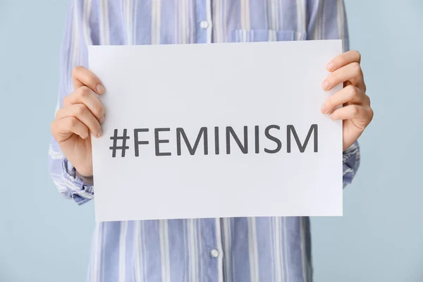 Mujer Sosteniendo Hoja Papel Con Palabra Feminismo Hashtag Sobre Fondo — Foto de Stock