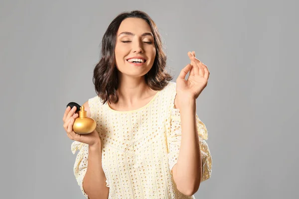 Bella Giovane Donna Con Bottiglia Profumo Sfondo Grigio — Foto Stock