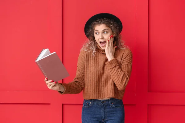 Verrast Jonge Vrouw Warme Trui Met Boek Kleur Achtergrond — Stockfoto