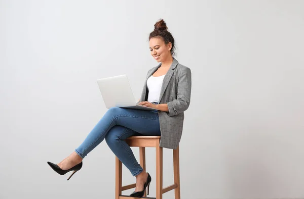 Junge Afroamerikanische Geschäftsfrau Sitzt Mit Laptop Auf Stuhl Neben Grauer — Stockfoto