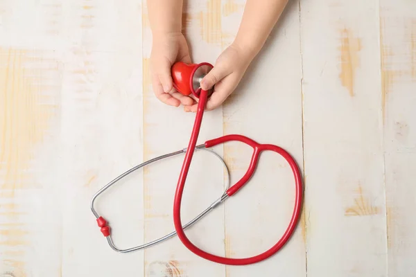 Child Hands Red Heart Stethoscope Wooden Background Cardiology Concept — Stock Photo, Image