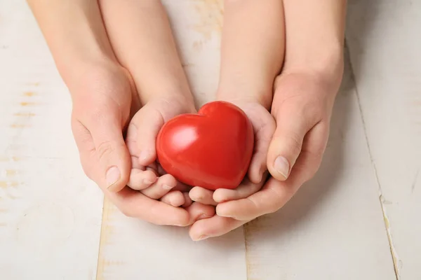 Mani Donna Bambino Con Cuore Rosso Sfondo Legno Concetto Cardiologia — Foto Stock