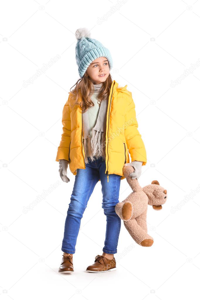 Cute little girl in winter clothes and with teddy bear on white background