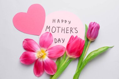 Beyaz arkaplanda anneler günü için güzel çiçekler ve kart.