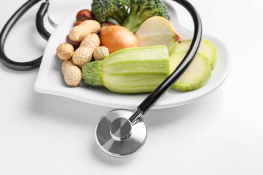 Sağlıklı ürünler ve beyaz arkaplanda steteskop.