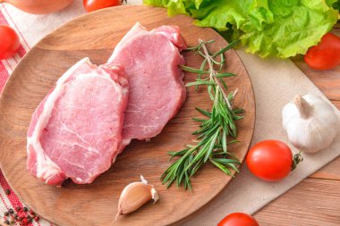 Tabakta çiğ domuz eti ve sebze var.