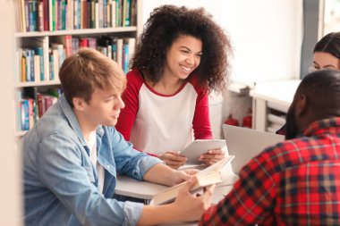 Kütüphanede sınava hazırlanan genç öğrenciler